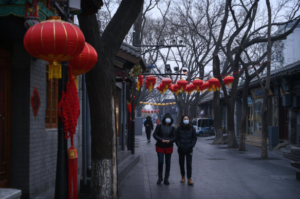 Chinese women walk in a usually busy shopping and tourist area during the Chinese New Year holiday in Beijing. The holiday has been extended to limit travel after the coronavirus outbreak.