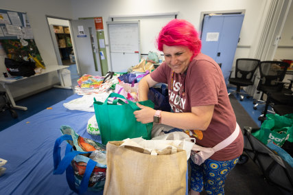 Adra Community Care food bank lead volunteer Stavi Gouros packs bags of food.