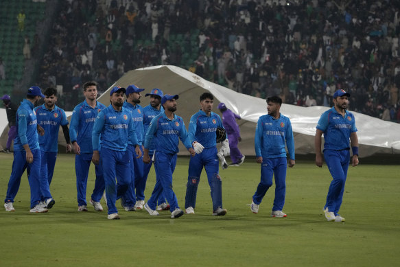 Afghanistan players walk off the field after rain stops the play.