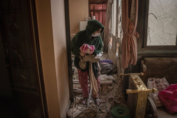 A woman gathers her belongings in an apartment in Baalbek, Lebanon, after an Israeli airstrike killed nine people the previous day.