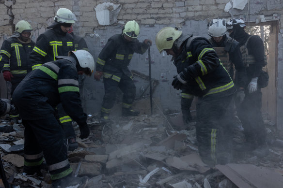 Firefighters work to clear the rubble at a destroyed village shop and café in Hroza, Ukraine. 