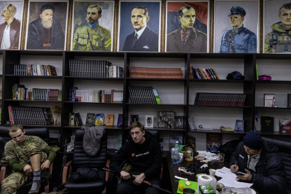 A civilian volunteer waits with his gun at a territorial defence unit registration office.