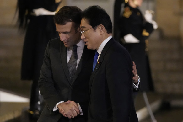 Closer: French President Emmanuel Macron, left, welcomes Japanese Prime Minister Fumio Kishida to Paris.