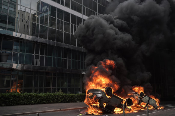 An overturned car burns during clashes between French police forces and youths.