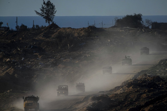 A convoy of Israeli troops moves in the Gaza Strip as seen from southern Israel on Thursday.