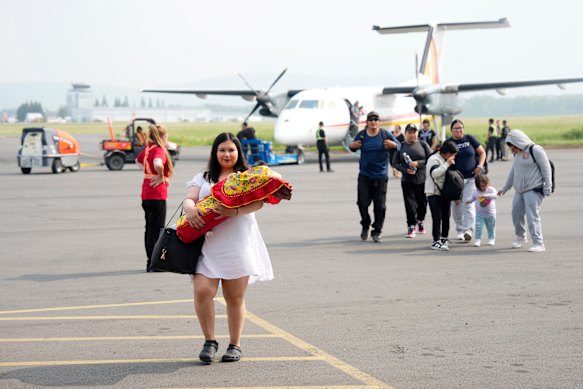 Neskantaga First Nation community members evacuated in response to the threat of wildfires and weather conditions arrive by plane in Thunder Bay, Ontario.