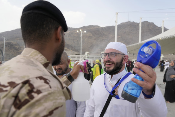 A pilgrim receives a cold water spray after he cast stones at a pillar in the symbolic stoning of the devil at Hajj.