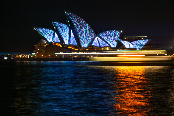 The sails of the Opera House are illuminated with lasers to celebrate its 50th anniversary.