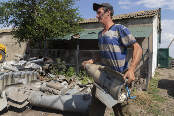 A farmer collects fragments of Russian rockets that he found on his field ten kilometres from the front line in the Dnipropetrovsk region.