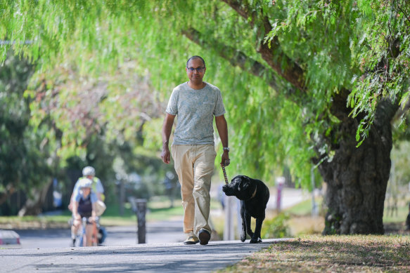 Fitzroy North resident Sudhan Mistry walks his dog Cola through his neighbourhood.