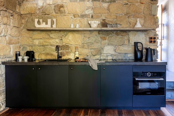 The kitchen is along one wall of an area that also contains the lounge room.