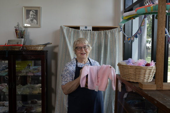 Branch president Margery East
shows off clothes made by the “crafty ladies”.