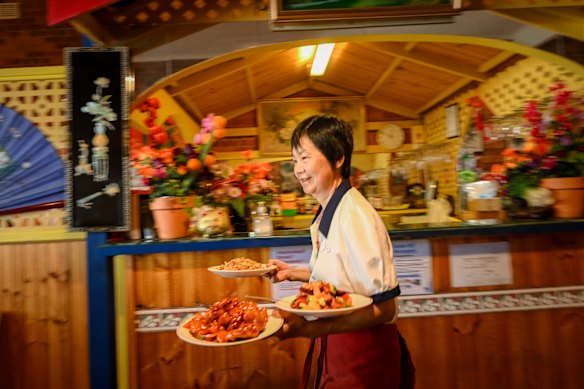 Connie Zhong serving BBQ pork chow mein and crispy sweet and sour fish at Flam Shan restaurant in Euroa
