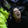 Police officers escort away a supporter of impeached South Korean President Yoon Suk Yeol.