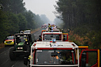 A firefighter stands on a truck on a road near Lacanau, southwestern France.
