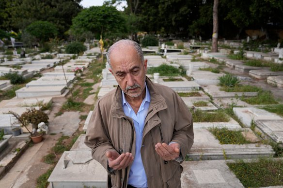 Mohammed Othman, a Palestinian survivor of the April 13, 1975 attack on a bus carrying Palestinians that sparked Lebanon’s civil war, prays over the graves of those killed that day, in Beirut, Lebanon.