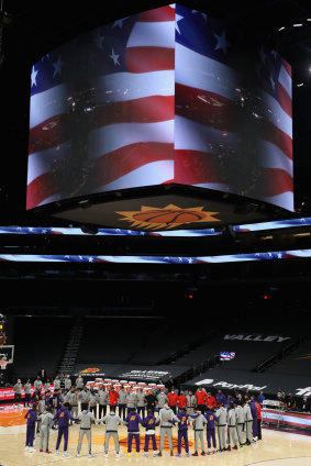 Toronto and Phoenix players stand arm in arm during the US and Canadian anthems.