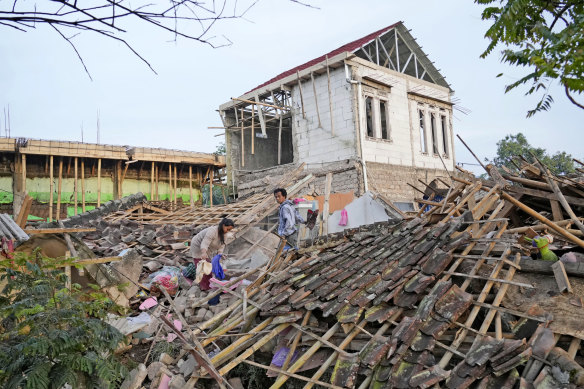 Earthquake survivors collect usable items from the ruins of their house in Cianjur, West Java.