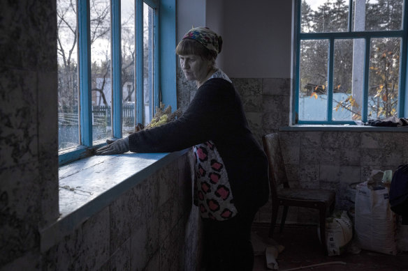 A woman cleans a windowsill at a home that was damaged during recent attacks.