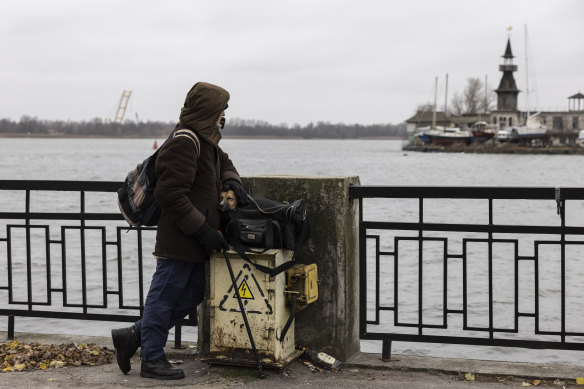 Yurii Senchuk, 74, keeps his dog Baikal warm in his travel bag as he waits at a port on the Dnieper River. 