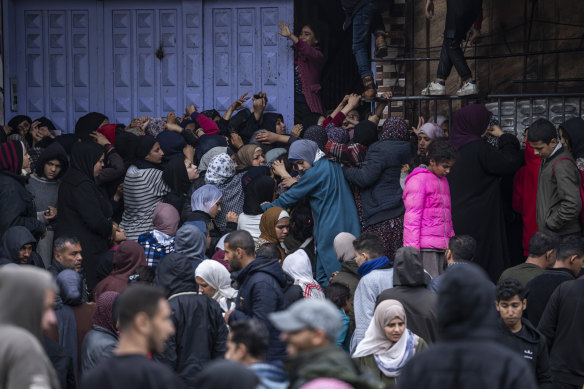 Palestinians attempt to buy bread from a bakery in Rafah on Sunday.