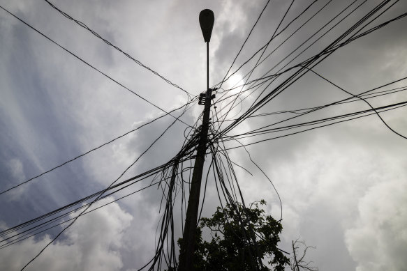 A utility pole with loose cables towers over the home of Jetsabel Osorio in Loiza, Puerto Rico.