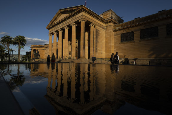 The Art Gallery of NSW at sunset with Karla Dicken’s glass panel installed above the entrance and hoarding down on the reflection pools.