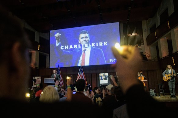 People hold candles and sing during a memorial and prayer vigil for Charlie Kirk at the John F. Kennedy Memorial Centre for the Performing Arts.