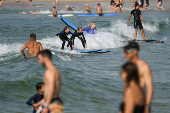 People swim and surf at Bondi Beach during a scorching day in Sydney.