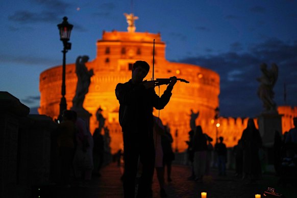 A street musician plays a violin outside the Sant’Angelo castle as the sun sets in Rome on Sunday.