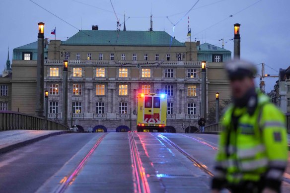 An ambulance drives towards the building of Philosophical Faculty of Charles University in downtown Prague.