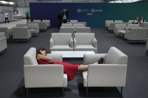 A woman rests as negotiations at COP28 in Dubai went into the night.