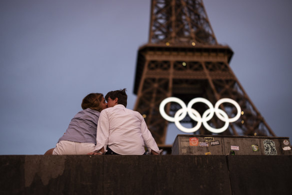 A young couple seal Paris’ Olympic and Paralympic preparations with a kiss.