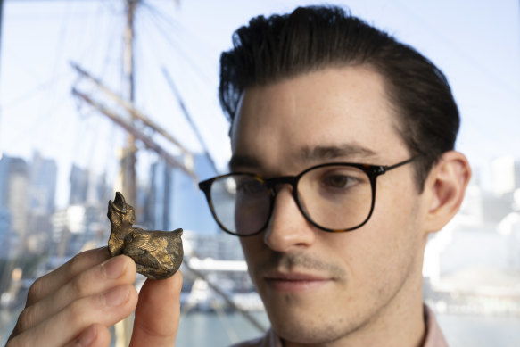 Conservator Jordan Aarsen at the Australian National Maritime Museum with a gaping fledgling from the wreck of the Dunbar.