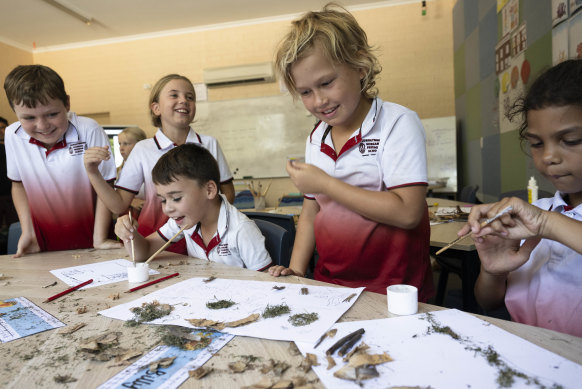 Students of Gumbaynggirr Giingana Freedom School make artwork from items they found on Country in Coffs Harbour.