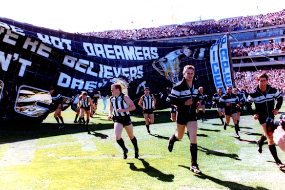 Collingwood run through the banner on grand final day in 1990.