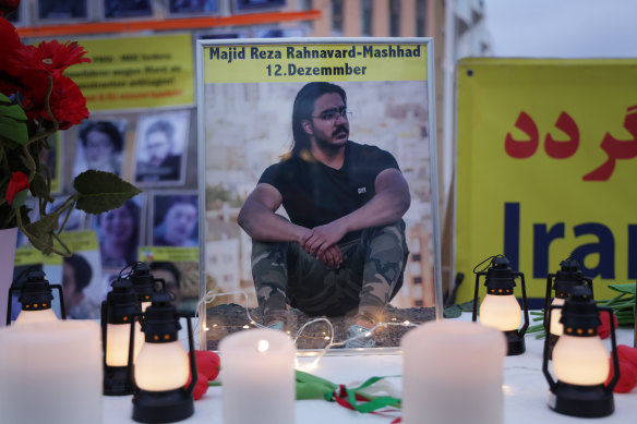 A photograph of Majid Reza Rahnavard stands on a table among candles during a demonstration by supporters of the National Council of Resistance of Iran outside the German Foreign Ministry in Berlin, Germany.