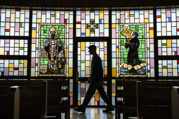 A parishioner walks within the Our Lady of Lebanon Cathedral, at Harris Park. 