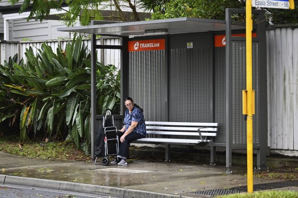 A woman waits for a Translink bus in Belmont on Brisbane’s Eastside. Delays are expected on the transport network as a result of heavy rains. 