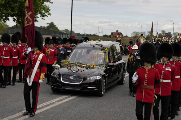 Grenadier Guards walk alongside the hearse carrying the coffin of Queen Elizabeth II as it arrives outside Windsor Castle.