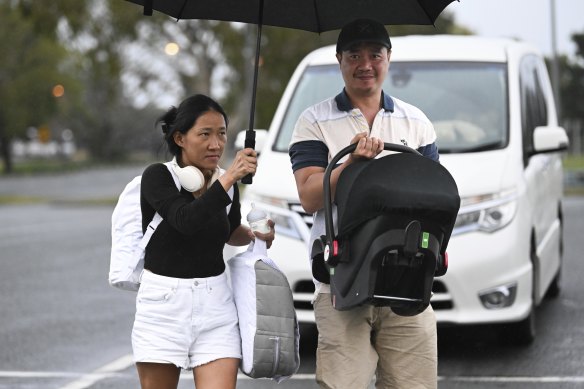 A couple with their young baby seek shelter at an evacuation centre at Runaway Bay.