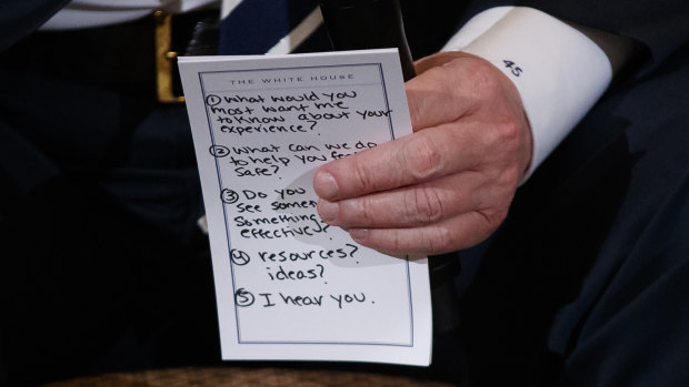 President Donald Trump holds notes during a listening session with high school students and teachers in the State Dining Room of the White House in Washington, DC.