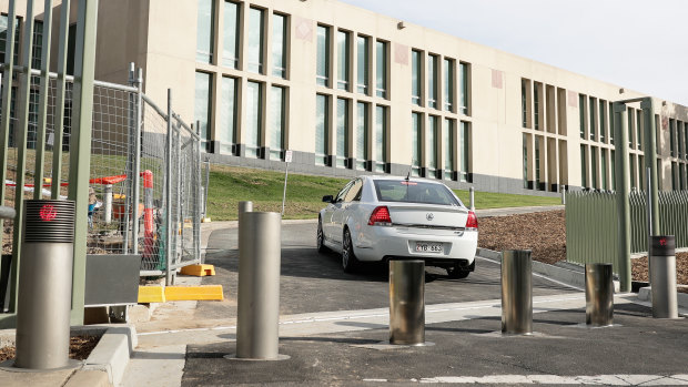 A Comcar enters the grounds of Parliament House by driving past drives past retractable bollards.