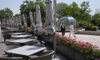 Shoppers pass by an empty outdoor area of a Beijing restaurant on Sunday. All restaurants in the capital are closed to dine-in customers from until the end of the May Day holiday on Wednesday.