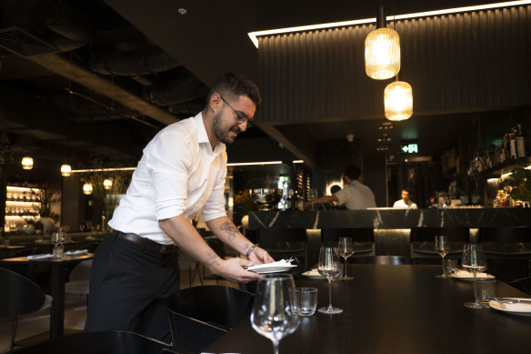 Soul Dining restaurant manager Kevin Moquet clears a table. The restaurant has had to pick up the bill for at least $2400 worth of meals.