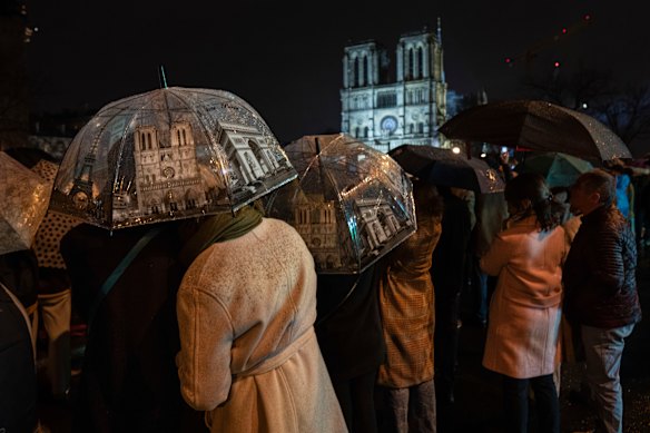 Spectators gather outside France’s iconic Notre Dame Cathedral Saturday, during it’s formal reopening in Paris. 