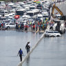 People walk along an flooded highway on April 18 in Dubai.