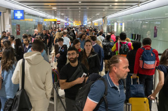 Travellers waiting in a long queue to pass through the security check at Heathrow. The airport is struggling to cope with the resurging travel demand.