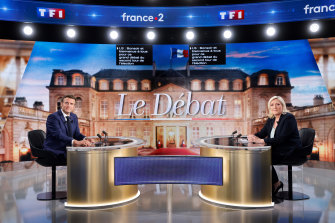 Centrist candidate and French President Emmanuel Macron, left, and far-right contender Marine Le Pen pose before a televised debate in La Plaine-Saint-Denis, outside Paris.