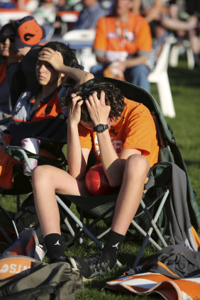 A Giants fan can't look during the grand final at the Homebush live site.